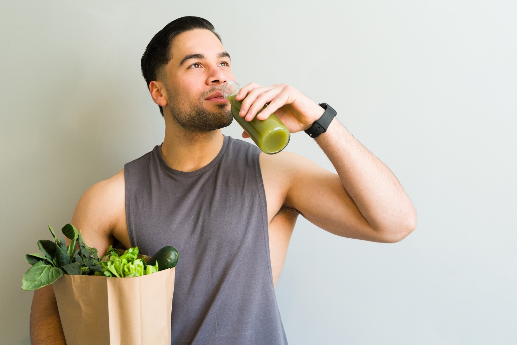 Young Athletic Man Drinking a Healthy Green Juice After Grocery Shopping, Promoting a Fit Lifestyle.
